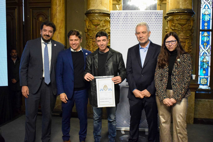 Familia recibiendo escritura de su vivienda junto a funcionarios provinciales